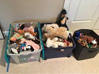 Three plastic bins filled with assorted Beanie Babies and plush animals, some TY tags visible