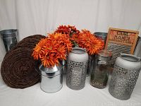 Full lot showing metal milk cans, metal pails, branch chargers, orange flowers, glass ball jar, metal lanterns, and vintage washboard.