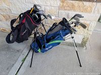 Two golf bags with multiple clubs visible, showing USKG and Fathom bags with clubs inside.