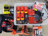 Full view of the lot with Black & Decker batteries, chargers, circular saw, Ryobi Bluetooth speaker, and Power Sharp sharpener.
