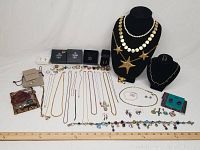 Wide overview showing necklaces on velvet busts, rings, bracelets, earrings and loose jewelry arranged on table