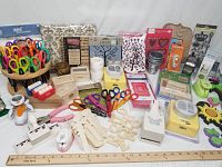 Overall view of the craft lot showing scissors carousel, punches, unfinished wood shapes, stencils, scrapbook album, wire rolls, stamps, and foam cutouts.