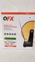 Front view of product box showing QFX branding, image of antenna, and key features like 60-mile range.