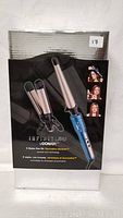 Front view of boxed Conair Infiniti Pro 3-in-1 hair styling kit showing the curling iron and two flat iron style attachments with blue handle.