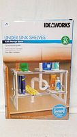 Front view of box showing product image of Ideaworks under sink shelves and branding.