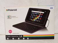 Polaroid brand box showing 9 inch tablet with keyboard case, L9 model, Android 5.0 Lollipop, features icons for quad core processor, dual cameras, Wi-Fi and Bluetooth.