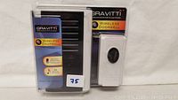 Photo of new Gravitti wireless doorbell in original plastic packaging showing transmitter and receiver units.