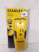 Opened packaging showing the yellow Stanley S100 Stud Sensor with black accents.