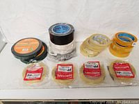 Lot of 16 assorted tape rolls including automobile mounting tape, packing tape and double-sided tapes shown together on white surface