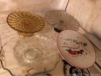 Top view of four pedestal cake platters including one Christmas-themed ceramic piece and three glass or crystal platters