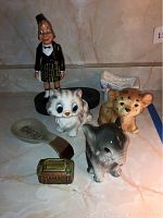 All seven ceramic pieces together showing three animal canisters, Irish figurine, shoe, pipe, and radio items
