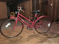 Side view of the red Fuji Avalon bicycle showing the full frame, two wheels with fenders, and seat.