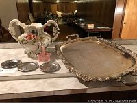 Photo showing the entire set on a countertop with the urn, large silver tray, three small silver trays, and pink basket.