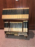 Photo of 1968 World Book Encyclopedia volumes with annual editions, dictionary, and atlas on custom wood stand.