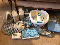 Overview photo showing nebulizers, foot spa, blood pressure monitor, heating pad, pill organizer and other items