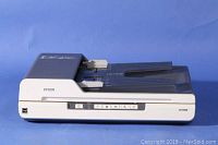 Side and top view of Epson GT-1500 scanner showing the automatic feeder tray and control buttons.