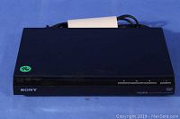 Front view of black Sony DVD player with visible brand logo and control buttons.