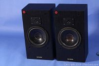 Pair of black wood grain Genexxa Model XG-500 speakers shown front facing, both speakers show woofer and tweeter, clean and intact.