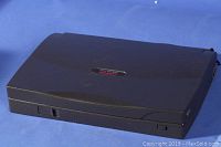 Closed Compaq Armada 1120 laptop showing dark gray lid with label, compact portable clamshell design.
