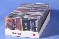 Full box of CDs arranged in rows, viewed from above showing many jewel cases.