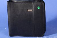 Large black binder-style CD storage case with smooth finish and cdProjects metal label on the front.