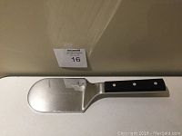 Full view of the Wusthof meat tenderizer showing its heavy stainless steel build, smooth tenderizing surface, and ergonomic handle with rivets.