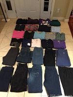 Photo showing folded tops and bottoms laid out on floor, 28 pieces total