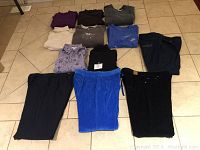 Photo of 12 used ladies clothing items, size XXL including tops and pants in various colors.
