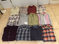 Photo showing all 12 men's shirts laid out on a tiled floor, displaying various patterns, colors, and styles including long and short sleeves.