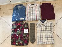 Five men's clothing items: blue shirt in package, maroon shirt, red/green plaid Dickies shirt, white plaid dress shirt, and gray patterned tie.