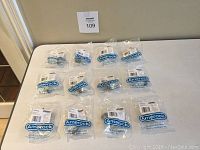 Full set of 12 new Amerock knobs still sealed in original plastic packaging with screws.