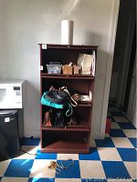 Frontal view of wooden storage cabinet showing multiple shelves and some items inside (not included). Measures approximately 28x12x60 inches.