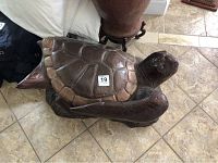 Top and side view of the brown concrete sea turtle on a tiled floor showing detailed shell and head.