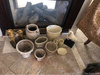 All planters and sculptures arranged on the hearth of a fireplace