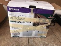 Original packaging box for Yamaha NS-AW190WH outdoor speakers, showing branding and model info.
