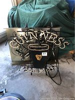 Disassembled neon tubes and metal backing showing harp logo and “DRAUGHT” text for Guinness sign
