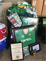 Framed Ireland soccer jersey with OPEL logo, UEFA Cup pennant, signed flag, and memorabilia arranged together.