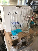 Two clear drinking glasses on boxes; one with Bud Light logo and one with Radeberger logo, with boxes labeled for total counts (Bud Light 11, Radeberger 6).