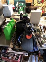 Overview of various sports and outdoor gear items including bubble solution bottles, diving fin, and other sports equipment on a table.