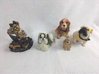 Five miniature dog figurines displayed in a row against a white background.