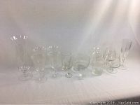 A group photo showing 14 pieces of clear crystal glassware including various stemmed glasses and a tall vase