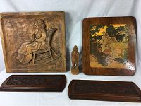 Full display of lot including large carved panel of woman in rocking chair, small carved figure, framed artwork, and two decorative panels.