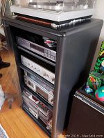 Full view of turntable on top and stacked components in black metal rack