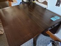 Top view of the vintage wooden drop leaf table showing the full surface with some scratches.