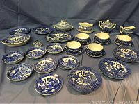 Full set view of Blue Willow children's tea set with all items spread out against a gray background.