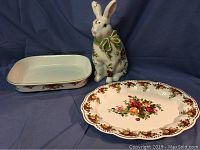 Overview of platter, casserole dish, and rabbit figurine against backdrop