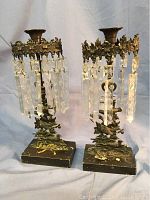 Full view of the pair of vintage wrought iron candelabras with hanging etched crystal prisms showing overall condition and design.