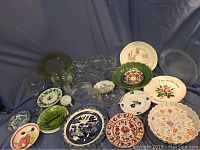 Overview of the collection of varied plates and serving dishes, showing multiple colors, materials, patterns and sizes.