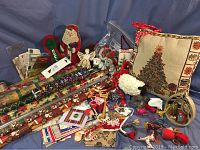Photo of assorted Christmas wrapping paper rolls, holiday pillows, and various Christmas decor and ornaments