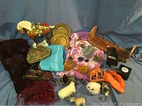 Overview of travel souvenirs including figurines, scarves, brass plates, plush animals, and wooden shelf.